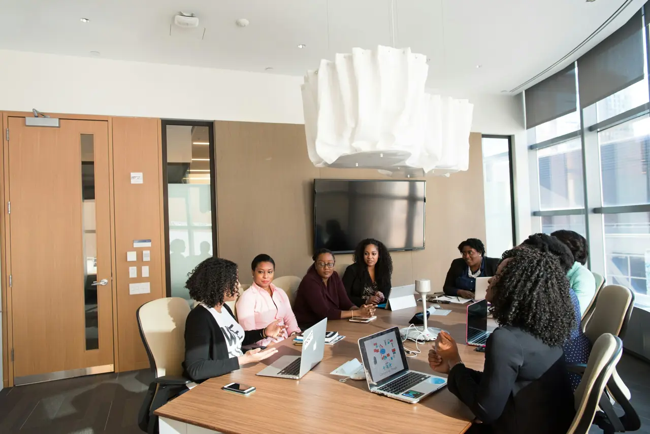 Réunion de travail autour d'une table, dans une salle de réunion à grande baie vitrée