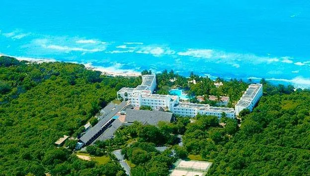 Vue aérienne du Kaskazi Beach Hotel : bâtiments blancs dans la verdure, face à l'océan Indien